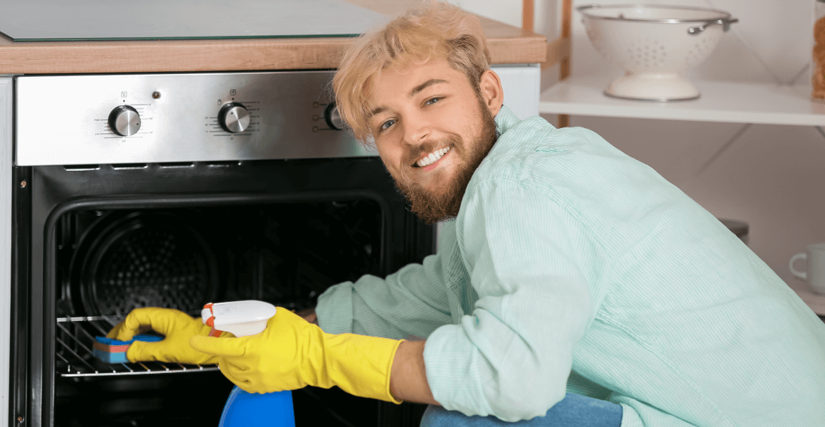 51565bb2 young man cleaning oven kitchen 1.png
